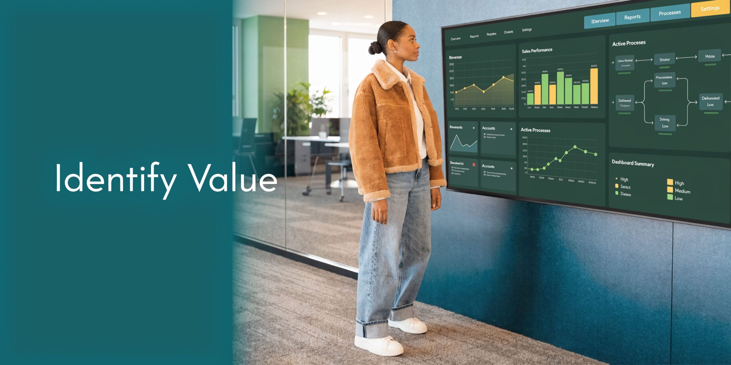A woman observing a large digital dashboard showing performance analytics and process workflows in a modern office.
